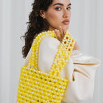 Azura glass beaded shoulder bag with model in yellow by MAREN LILIAN
